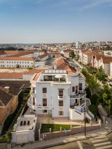 une vue aérienne sur un bâtiment blanc dans une ville dans l'établissement Penedo da Saudade Suites & Hostel, à Coimbra