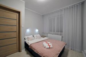 een slaapkamer met een bed met twee handdoeken erop bij Dream Apartment in Suwałki