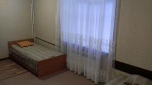 um quarto com uma cama e uma janela com cortinas em вулиця Пушкінська67/69 em Carcóvia