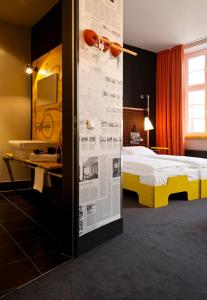 a bedroom with a bed and a wall with a newspaper at Superbude Hamburg St Pauli in Hamburg