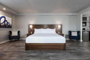 Una cama o camas en una habitación de Imperia Hôtel et Suites Boucherville