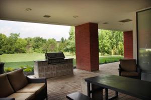 een patio met een grill en een tafel en stoelen bij Residence & Conference Centre - Brampton in Brampton