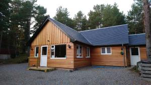 une grande cabane en bois avec un garage dans l'établissement Camping Pod Heaven, à Brackla