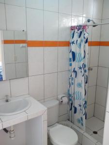 y baño con aseo, lavabo y ducha. en Paracas Backpackers House, en Paracas