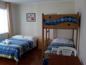 1 dormitorio con 2 literas y mesa en Paracas Backpackers House, en Paracas