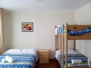 1 dormitorio con 2 literas y escalera en Paracas Backpackers House, en Paracas