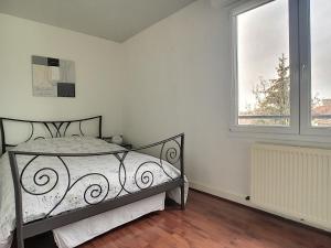 1 dormitorio con cama y ventana en Echapée belle proche gare et centre ville, en Châlons-en-Champagne