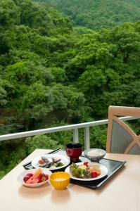 einen Tisch mit 2 Tellern Essen auf einem Balkon in der Unterkunft Yoshikawaya in Fukushima