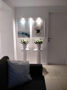 uma sala de estar com um sofá e dois vasos com flores em Milan Center big Luxury House em Sesto San Giovanni