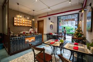 um restaurante com mesas e cadeiras e uma árvore de Natal em Little Saigon Boutique Hotel em Cidade de Ho Chi Minh