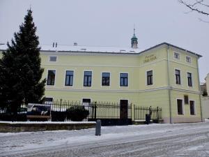 un edificio amarillo con una valla delante en Penzion Stará pošta, en Frýdek-Místek