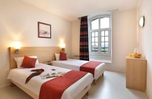 a hotel room with two beds and a window at Vacancéole - Les Demeures Champenoises in Épernay