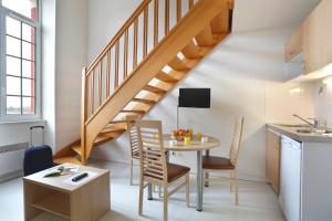 a kitchen and dining room with a table and a staircase at Vacancéole - Les Demeures Champenoises in Épernay