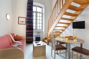 a living room with a couch and a table and a staircase at Vacancéole - Les Demeures Champenoises in Épernay