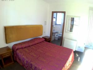 Schlafzimmer mit einem Bett mit einer roten Tagesdecke in der Unterkunft Podere 269 in Castiglione della Pescaia