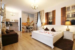 1 dormitorio con 1 cama blanca y sala de estar en Arhivelor Apartment, en Sibiu