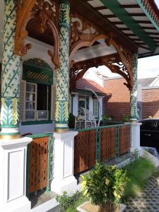 een huis met een veranda met een houten hek bij Rumah Jawa Guest House (Syariah) in Yogyakarta