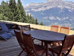 einen Tisch und Stühle auf einer Terrasse mit Bergblick in der Unterkunft Le Refuge in Cordon