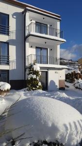 una casa bianca con la neve davanti di Willa Karo a Muszyna