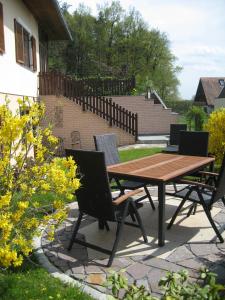 einen Holztisch und Stühle auf einer Terrasse in der Unterkunft Ferienwohnung-Hajek in Sankt Ruprecht an der Raab