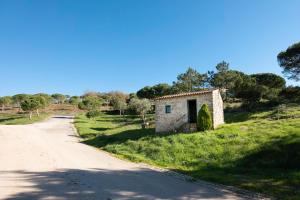 un pequeño edificio de piedra al lado de una carretera en Casa Rústica, perto do Castelo de Óbidos, en Óbidos