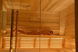 een vrouw ligt in een sauna bij Family Hotel Gran Baita in Pozza di Fassa