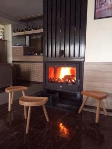 een open haard met twee stoelen ervoor bij Hotel Millenium2 in Prizren