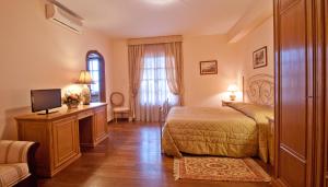 a bedroom with a bed and a desk and a television at Tenuta Cusmano in Grottaferrata