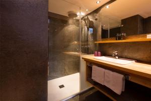 a bathroom with a sink and a shower at Hotel Sandhof in Lech am Arlberg