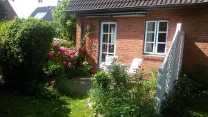 een stenen huis met een raam en bloemen in de tuin bij Ferienwohnung Seidler in Rendsburg