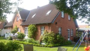 een rood bakstenen huis met een speeltuin ervoor bij Ferienwohnung Seidler in Rendsburg