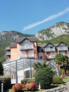 Une rangée de maisons avec une montagne en arrière-plan dans l'établissement Hôtel Chez Pierre d'Agos, à Agos-Vidalos