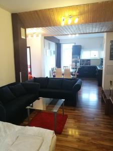 sala de estar con sofá negro y mesa en Apartment Maximilian, en Bratislava