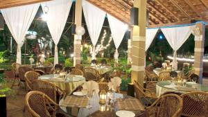 um restaurante ao ar livre com mesas, cadeiras e luzes em Shivers Oasis Luxury Boutique Resort em Candolim