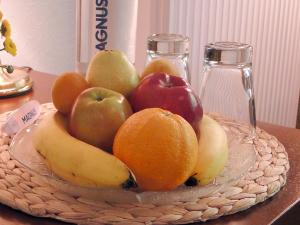 un bol de fruits sur une plaque de verre sur une table dans l'établissement Hotel Zum Goldenen Hirsch, à Bad Bevensen