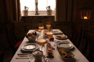 een tafel met borden en glazen sinaasappelsap bij Hotel Casa de las Cuatro Torres in Cádiz