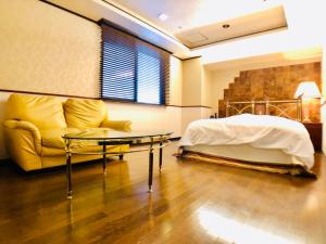 1 dormitorio con cama, sofá y mesa en Hotel Ritz Koshien, en Nishinomiya