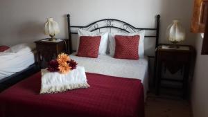 1 dormitorio con 1 cama con almohadas rojas y blancas en Quinta Das Lameirinhas, en Marvão