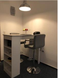 an office with a desk with a chair and a lamp at Ferienwohnung ADARO in Schleswig