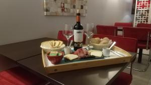 una mesa con una bandeja de queso y una botella de vino en Aires da Serra Hotel, en Torres Novas