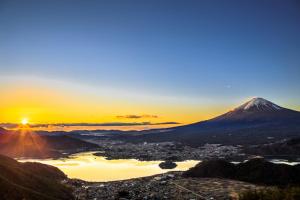 富士河口湖Habitacion NIIYA Mt Fuji的日落时分享有城市和山脉的景致