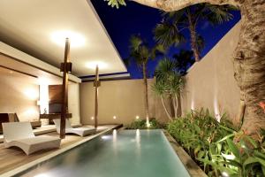 une piscine intérieure dans une maison avec un arbre dans l'établissement Asa Bali Luxury Villas & Spa, à Seminyak