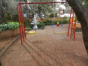 a playground with red metal poles in a park at Sayeban Hotel in Matheran