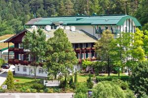 un grande edificio bianco con tetto verde di Hotel Schneeberghof a Puchberg am Schneeberg