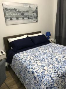 1 dormitorio con 1 cama con edredón azul y blanco en Mamma Roma 151, en Roma