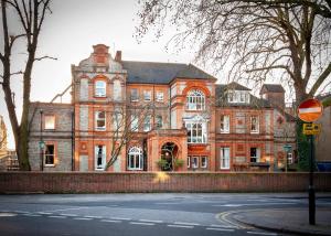 a large brick building on the side of a street at Palmers Lodge Swiss Cottage in London