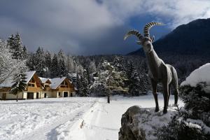 een standbeeld van een berggeit in de sneeuw bij Jasna Chalet Resort in Kranjska Gora