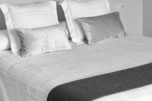 a black and white photo of a bed with pillows at Sevilla Aljarafe Room in Bormujos