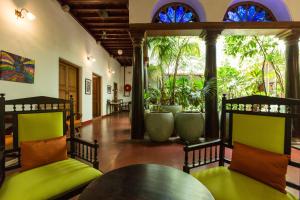 um quarto com mesa, cadeiras e plantas em Maison Perumal Pondicherry - a CGH Earth Experience em Pondicherry