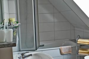 a bathroom with a shower and a sink and a tub at Urseetalblick in Lenzkirch